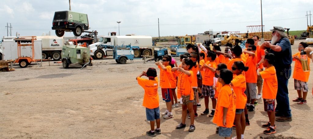 Randall teaching children from an after-school program crane operator signals